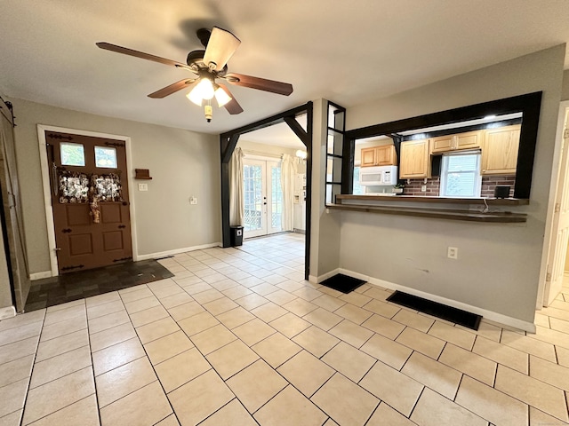 foyer with ceiling fan and light tile patterned floors