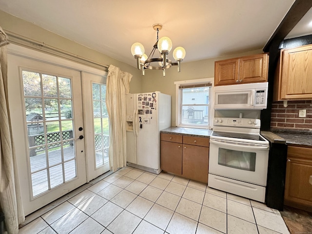 kitchen with hanging light fixtures, plenty of natural light, a chandelier, and white appliances