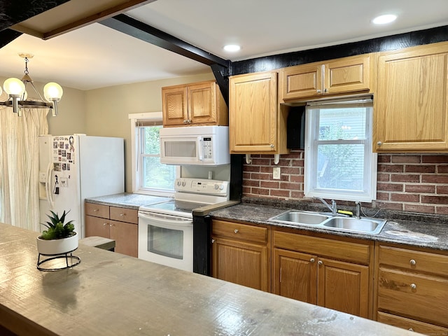 kitchen featuring pendant lighting, white appliances, sink, decorative backsplash, and a chandelier