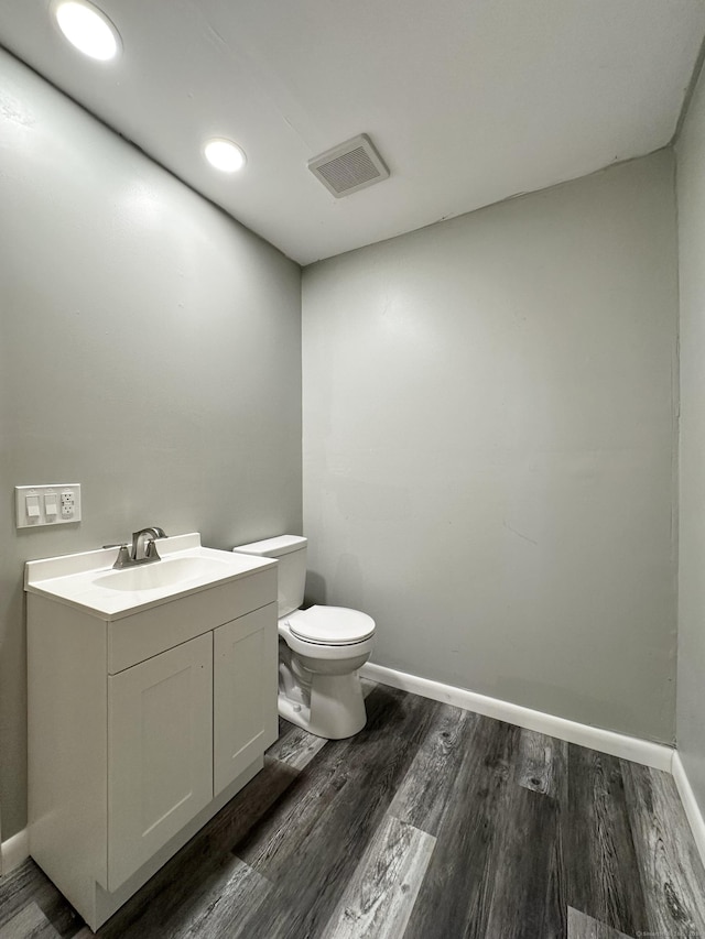 bathroom featuring hardwood / wood-style flooring, vanity, and toilet