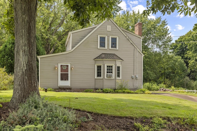 back of property featuring a lawn