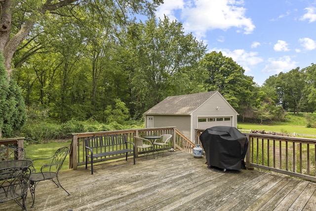 wooden terrace with a garage, an outdoor structure, and a grill