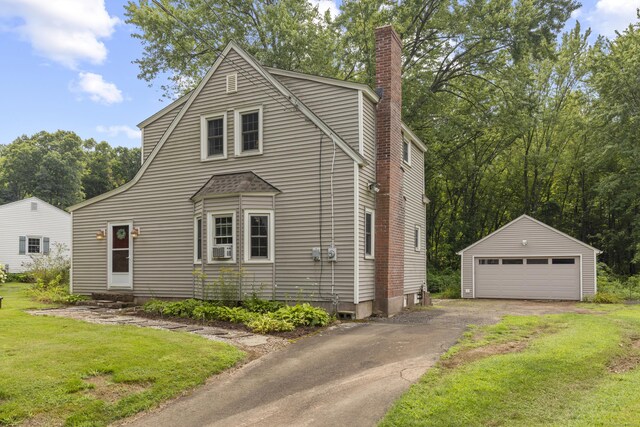 view of front of home featuring a garage, an outdoor structure, and a front yard