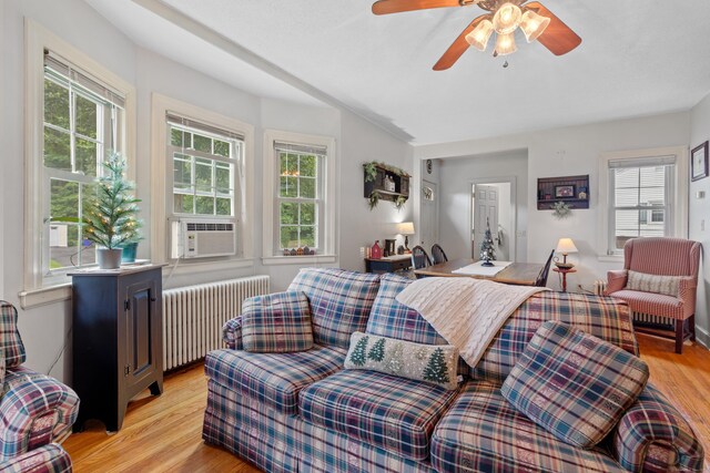 living room with light wood-type flooring, radiator, cooling unit, and ceiling fan