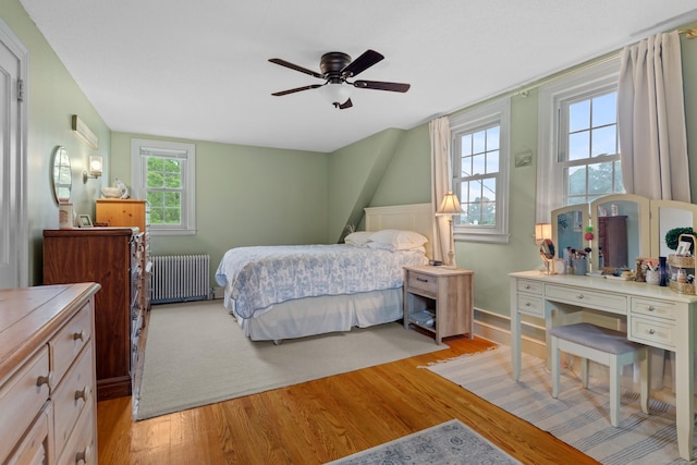 bedroom featuring ceiling fan, light hardwood / wood-style floors, and radiator