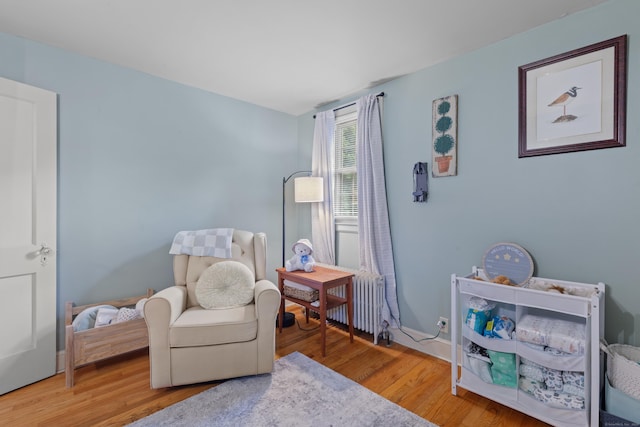 living area featuring radiator and hardwood / wood-style floors