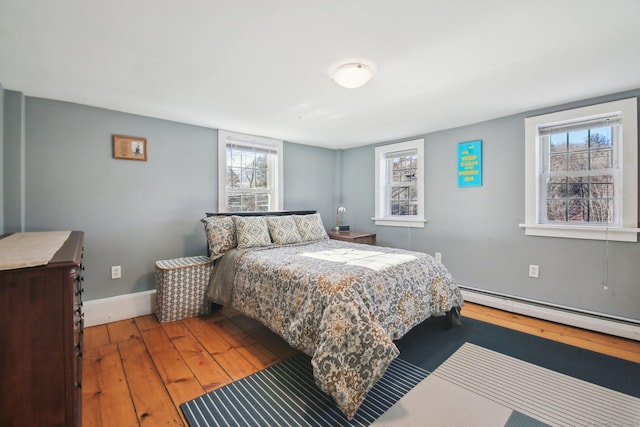 bedroom with hardwood / wood-style flooring and a baseboard heating unit