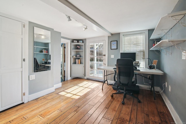 office area featuring built in shelves and light hardwood / wood-style flooring