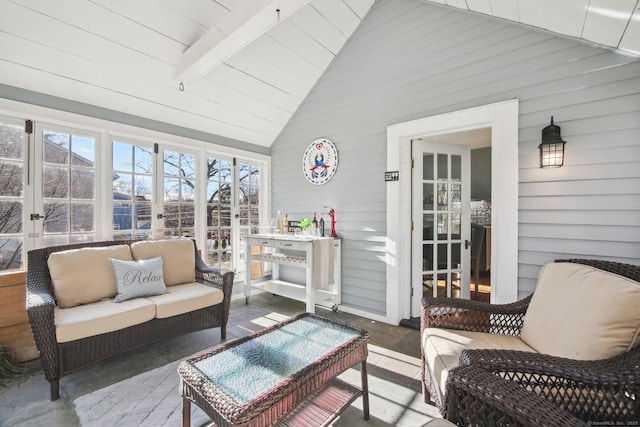 sunroom / solarium featuring vaulted ceiling with beams