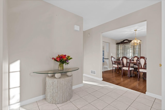 foyer with light tile patterned floors and an inviting chandelier