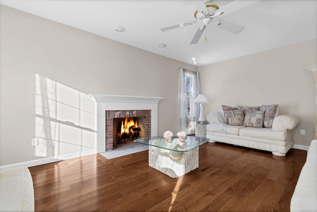 unfurnished living room with dark wood-type flooring, ceiling fan, and a fireplace