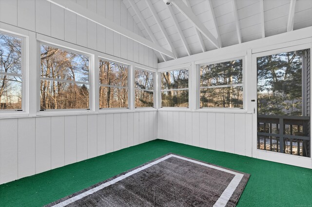 unfurnished sunroom featuring lofted ceiling with beams