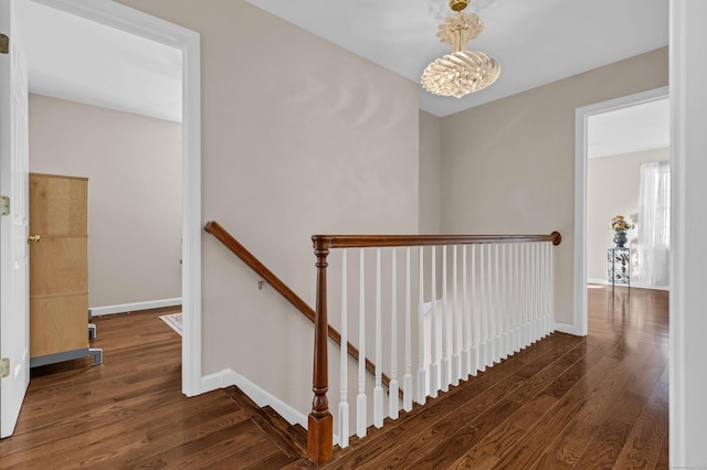 stairs featuring wood-type flooring and a chandelier