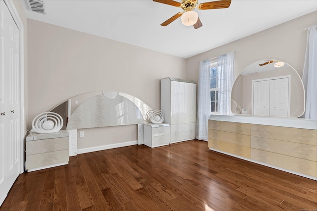 unfurnished bedroom with dark wood-type flooring, ceiling fan, and a closet