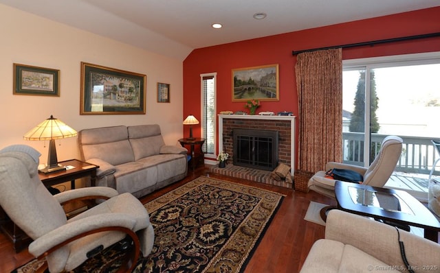 living room with a fireplace, dark hardwood / wood-style flooring, and vaulted ceiling