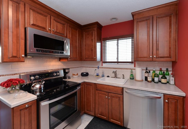 kitchen with backsplash, sink, light tile patterned floors, and stainless steel appliances