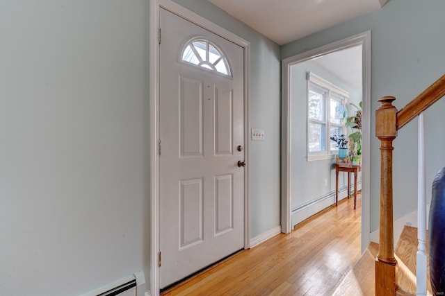 foyer entrance featuring a baseboard radiator and light hardwood / wood-style floors