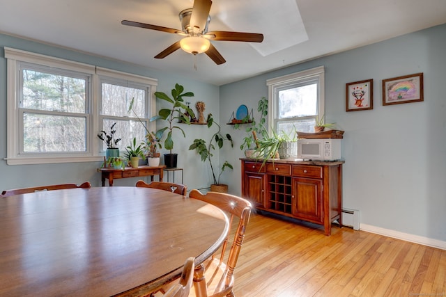 dining room featuring ceiling fan, light hardwood / wood-style floors, and a baseboard heating unit