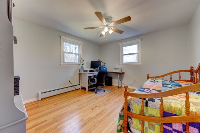 bedroom featuring multiple windows, ceiling fan, light wood-type flooring, and a baseboard heating unit