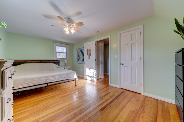 bedroom featuring light hardwood / wood-style floors, vaulted ceiling, and ceiling fan