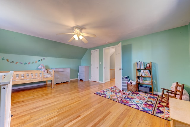 bedroom with hardwood / wood-style floors, vaulted ceiling, and ceiling fan