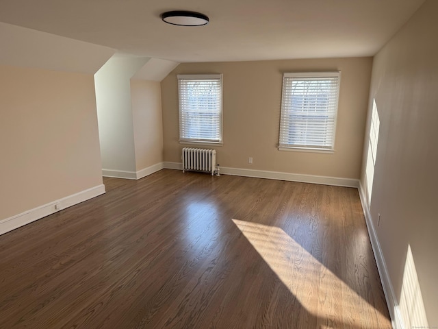 additional living space featuring dark hardwood / wood-style floors and radiator