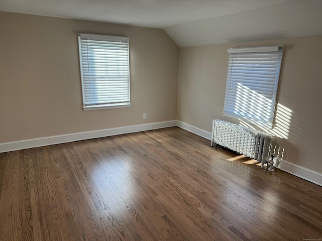 bonus room featuring radiator heating unit, dark hardwood / wood-style floors, and lofted ceiling