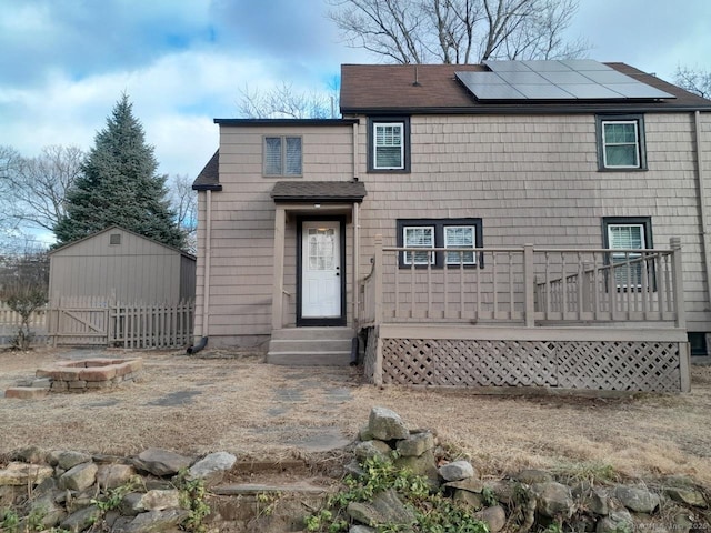 view of front of property featuring solar panels and an outdoor fire pit