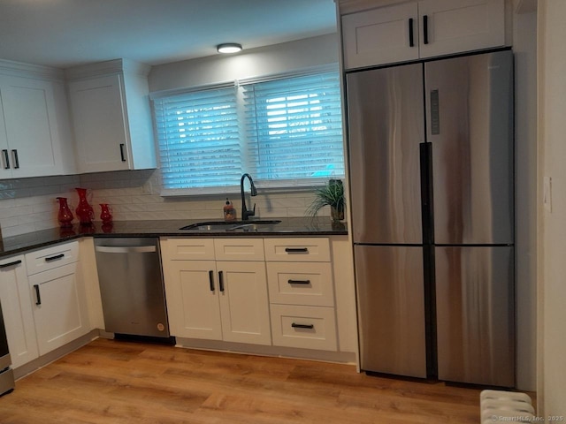 kitchen with white cabinets, sink, appliances with stainless steel finishes, and dark stone counters