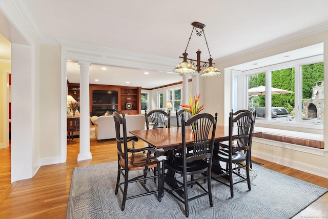 dining area with hardwood / wood-style floors, ornate columns, and ornamental molding