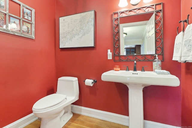 bathroom featuring hardwood / wood-style floors, toilet, and crown molding