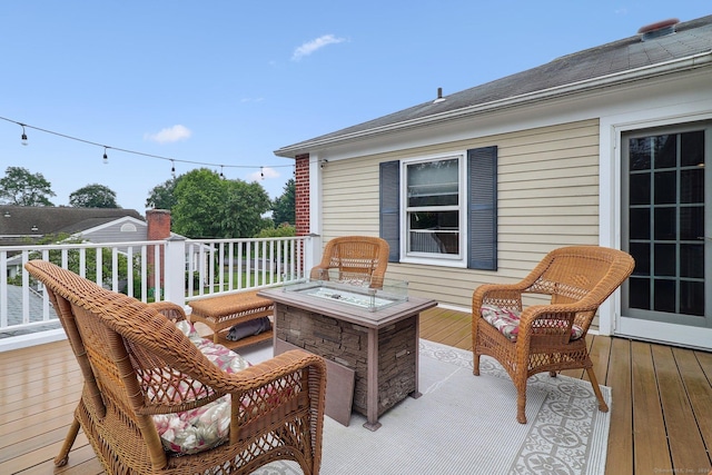 wooden terrace featuring an outdoor fire pit