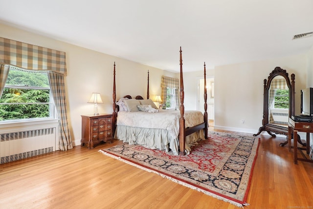 bedroom featuring wood-type flooring and radiator