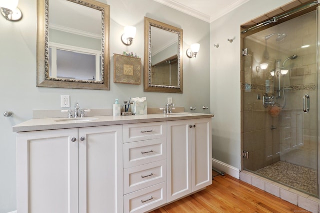 bathroom featuring vanity, hardwood / wood-style flooring, walk in shower, and crown molding