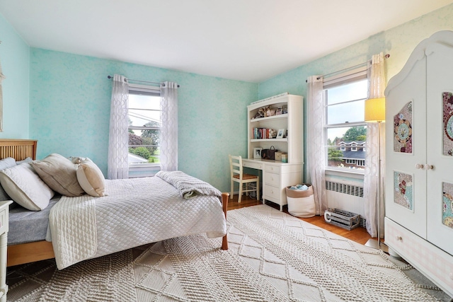 bedroom featuring radiator heating unit and light hardwood / wood-style floors