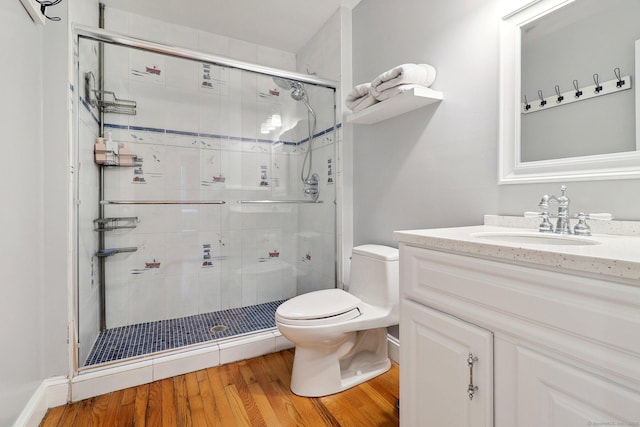 bathroom with vanity, toilet, wood-type flooring, and a shower with door