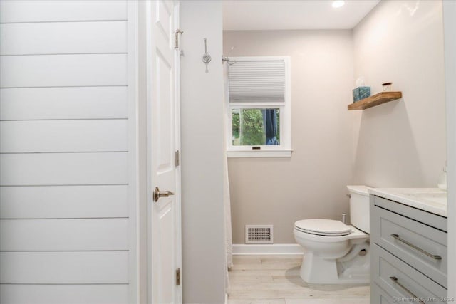 bathroom with hardwood / wood-style flooring, vanity, and toilet