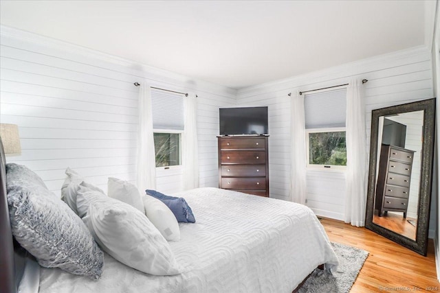 bedroom with hardwood / wood-style floors and wood walls