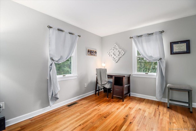 home office with light hardwood / wood-style floors