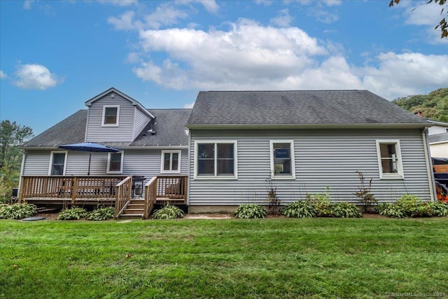 rear view of house with a lawn and a wooden deck