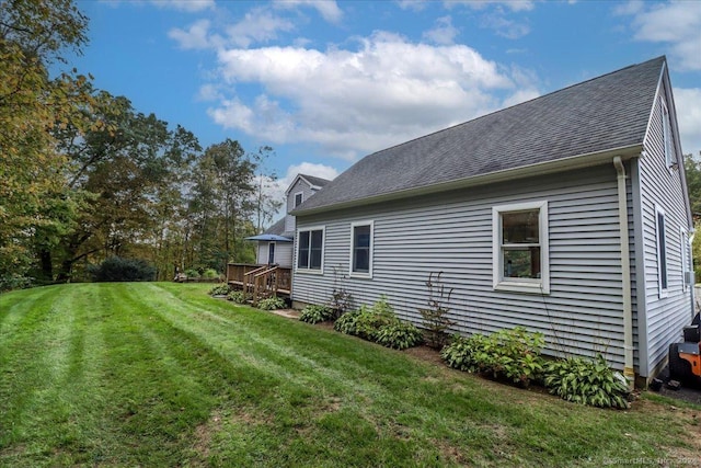 view of side of home with a lawn and a deck