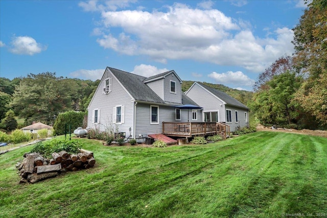 rear view of house with a lawn and a wooden deck