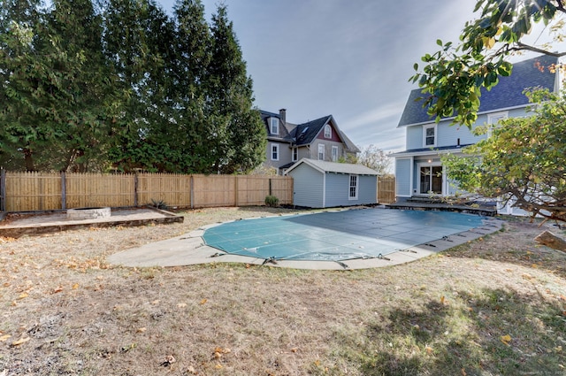 view of swimming pool with a patio and a storage unit