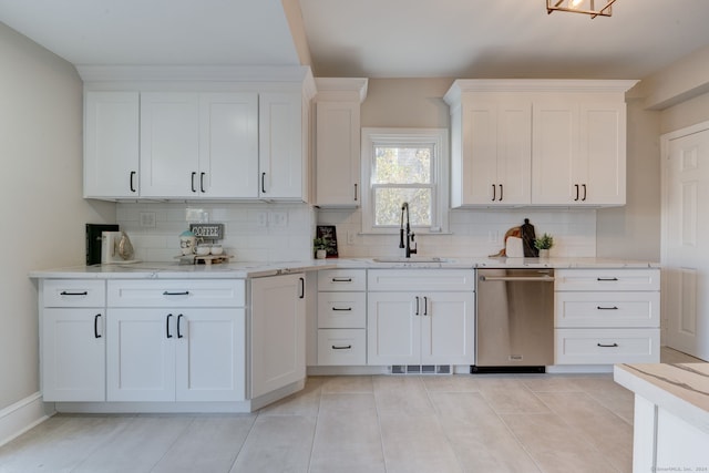 kitchen featuring dishwasher, sink, light tile patterned flooring, decorative backsplash, and white cabinets