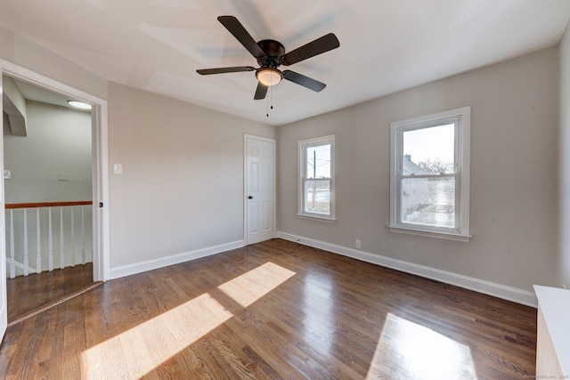 empty room with dark hardwood / wood-style floors and ceiling fan