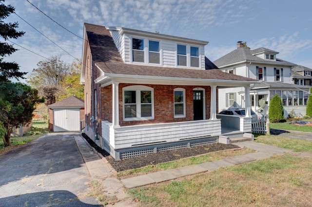 view of front of home with a porch and a storage shed