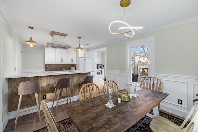 dining area featuring an inviting chandelier, crown molding, and wood-type flooring