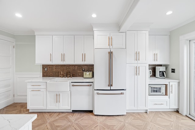 kitchen with light stone counters, sink, white appliances, and white cabinets