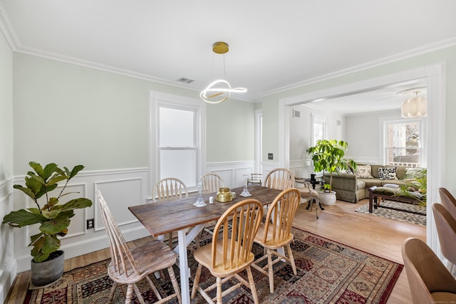 dining area featuring ornamental molding, a chandelier, and hardwood / wood-style floors