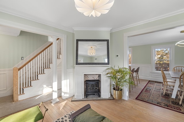 living room with crown molding, ornate columns, a chandelier, and hardwood / wood-style flooring